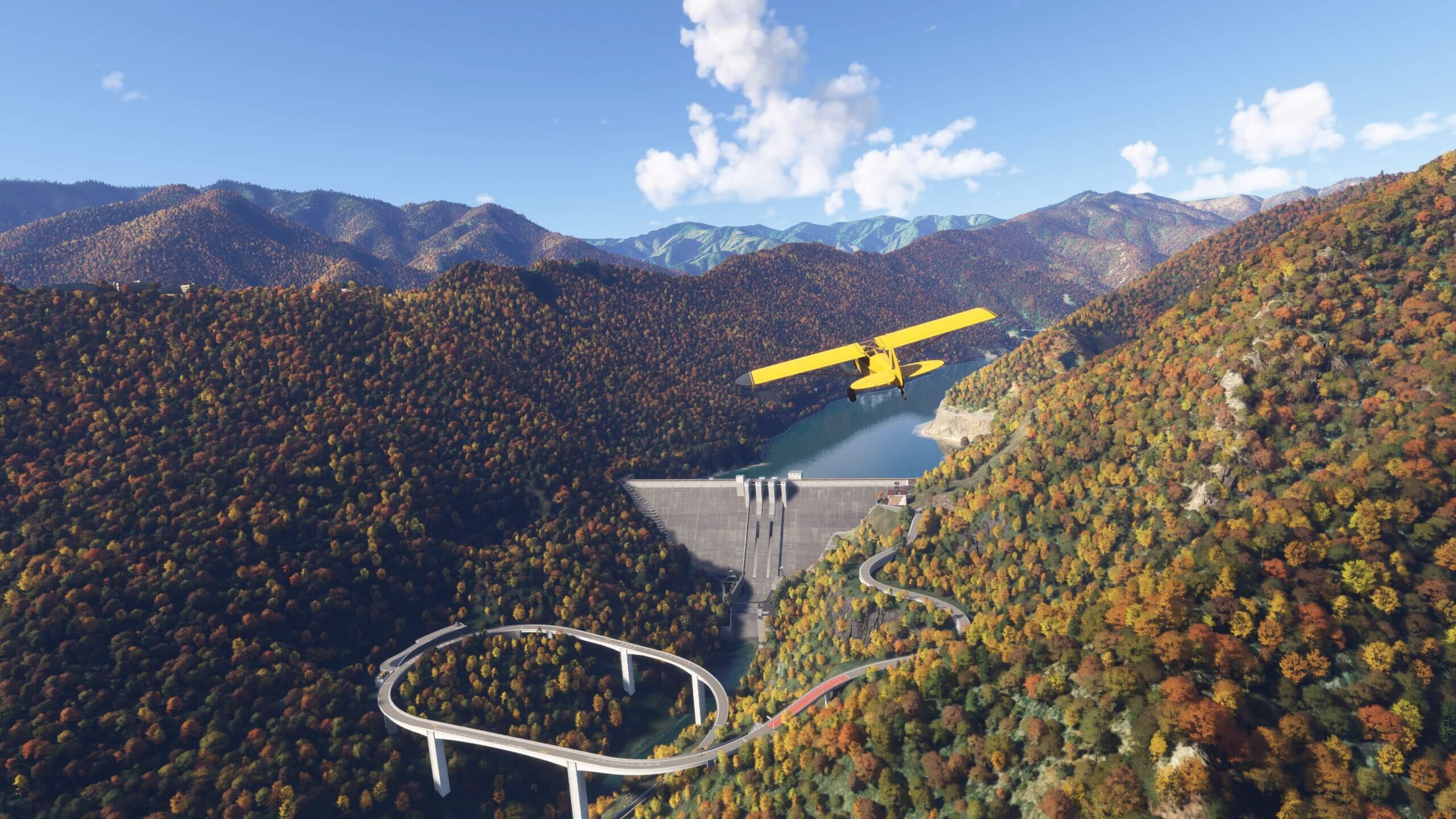 A high wing yellow propeller aircraft flies towards a Dam in the middle of a valley