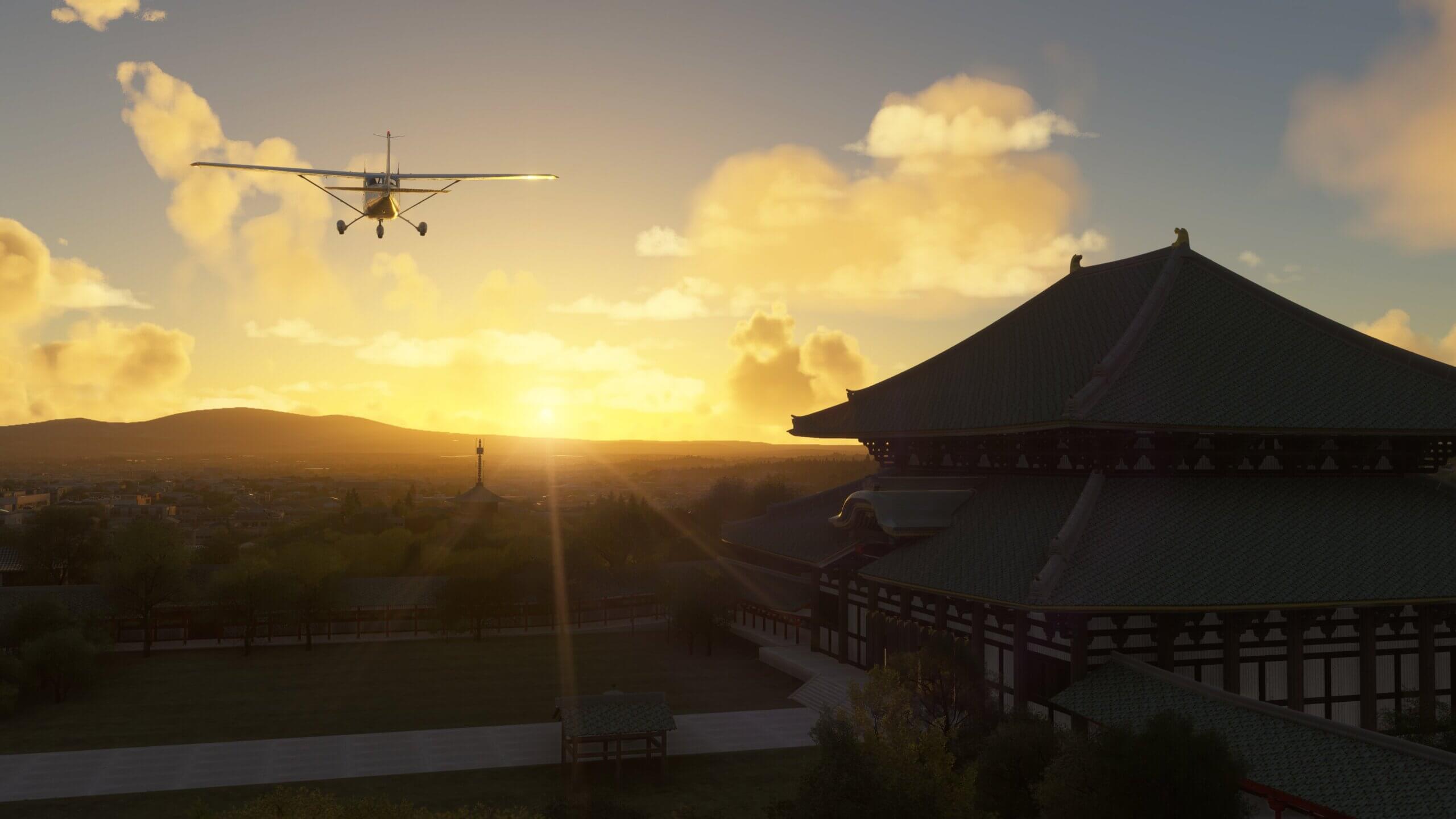 A Cessna 172 flies close to a historic Japanese building during sunset