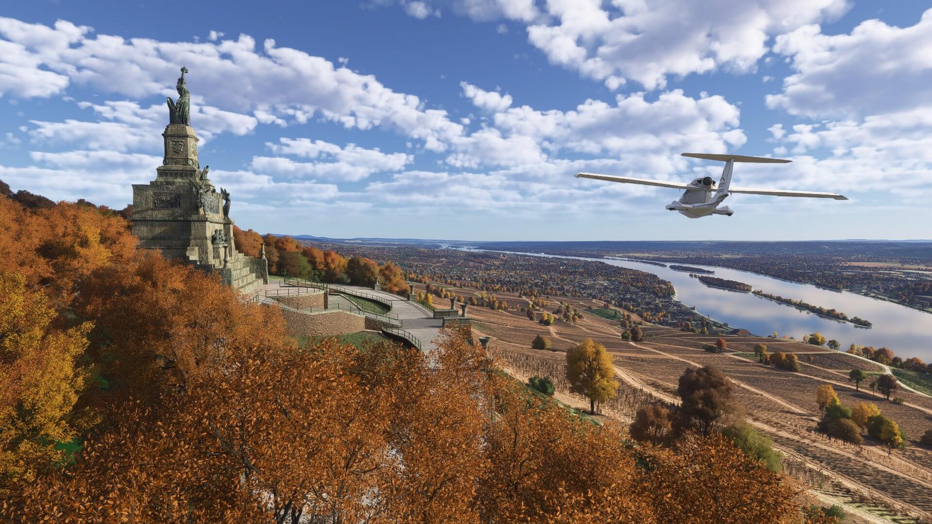 An Icon A5 passes a monument with autumnal trees surrounding
