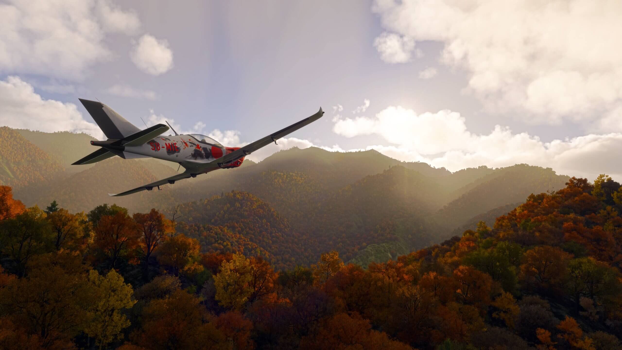A low wing propeller aircraft flies low through a mountainous area