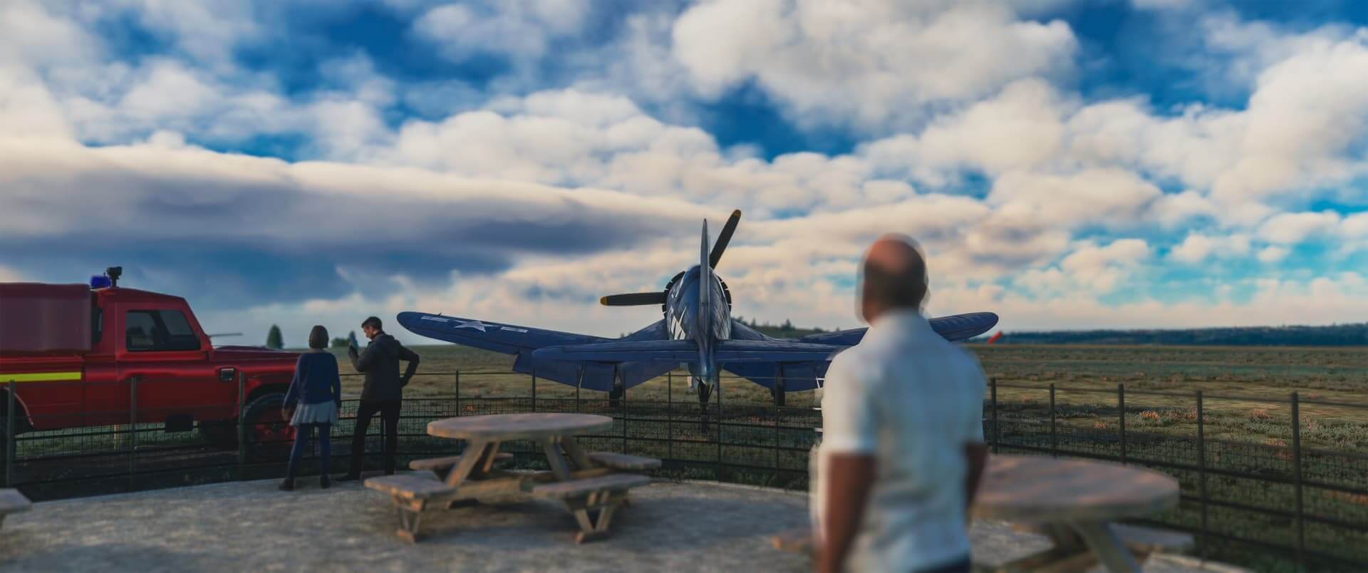 A pilot looks towards his aircraft parked on a grass ramp