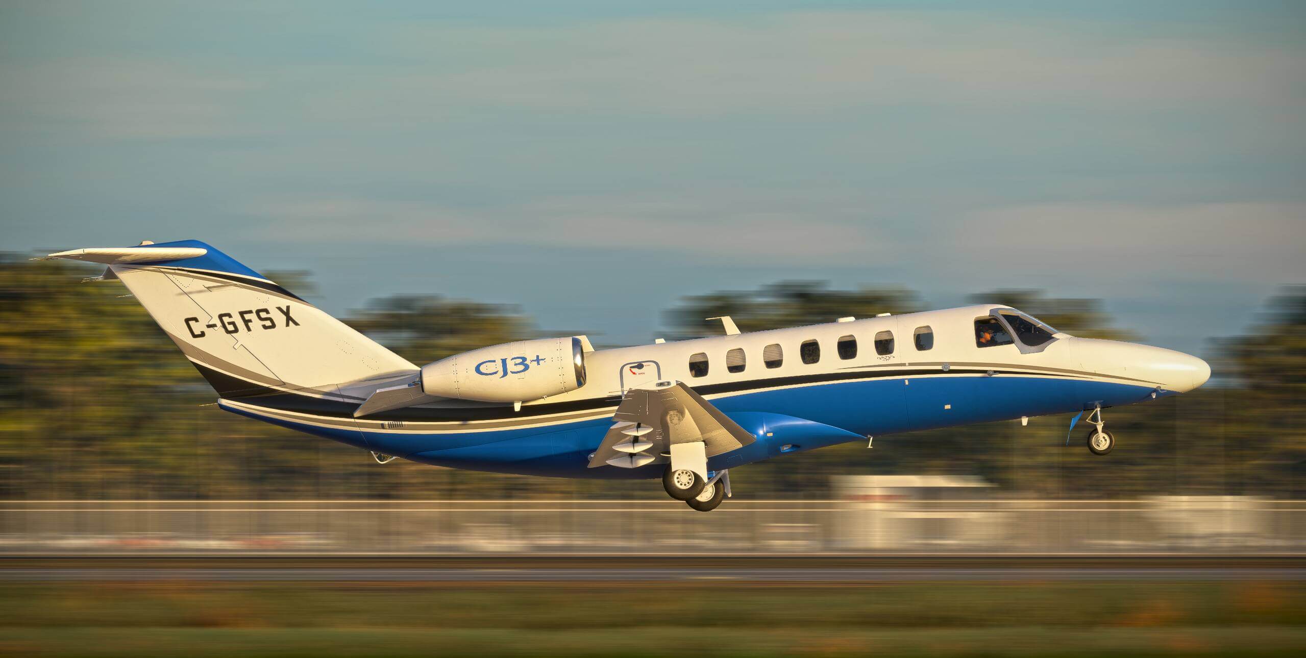 A private jet in white, blue, black, and silver color scheme flares for landing