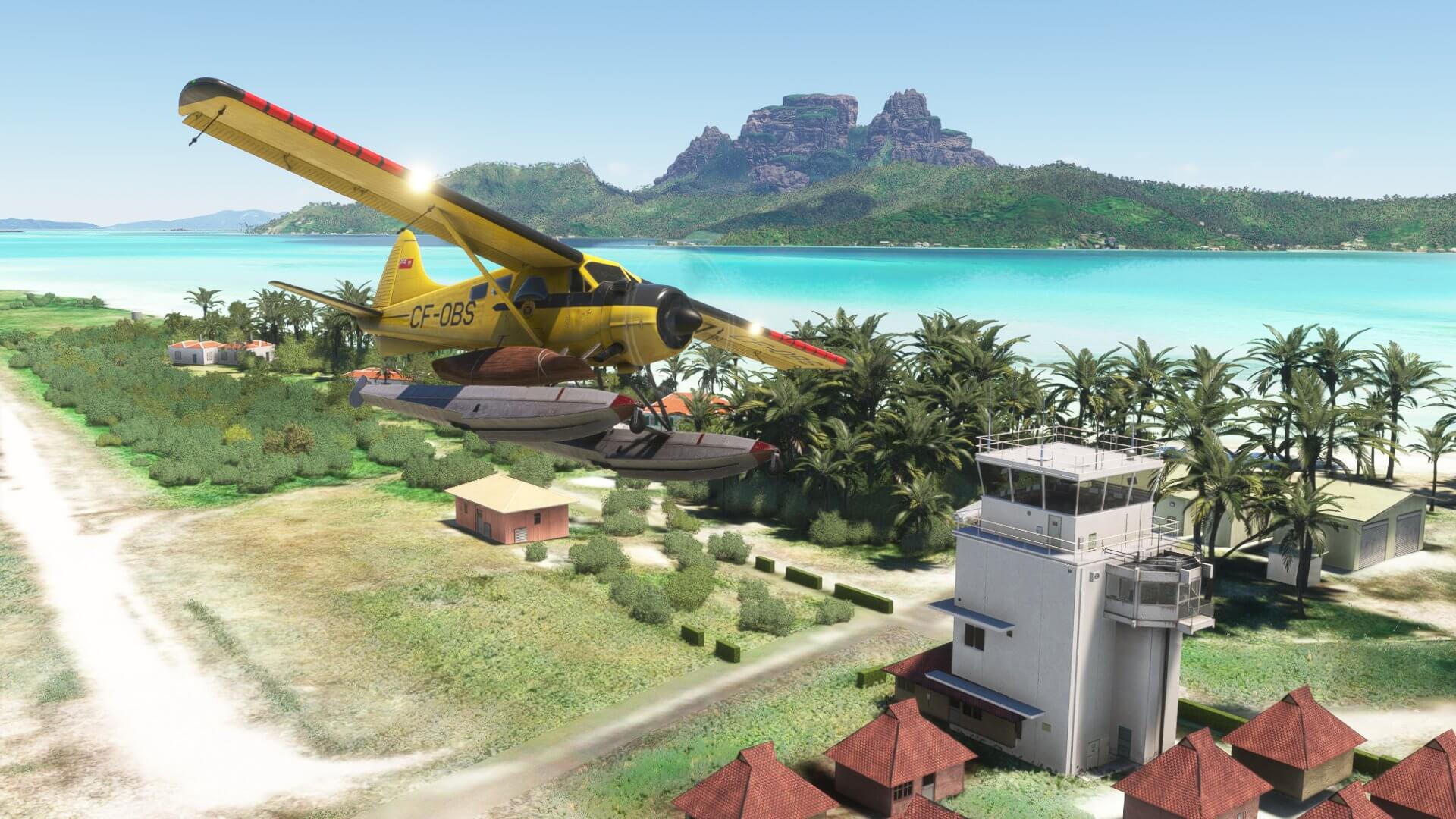 A high wing yellow prop aircraft flies past the tower at a Caribbean airport