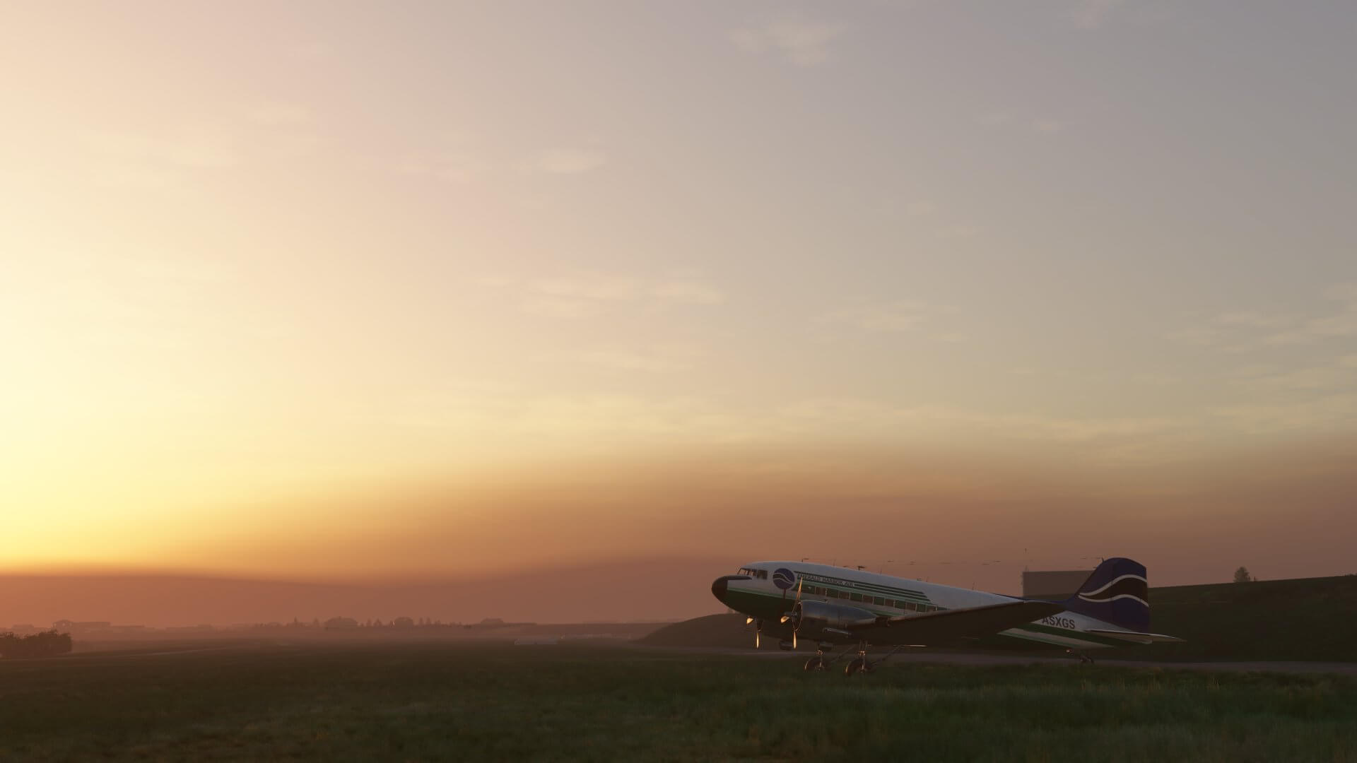 A DC-3 sat on an airport ramp during sunset