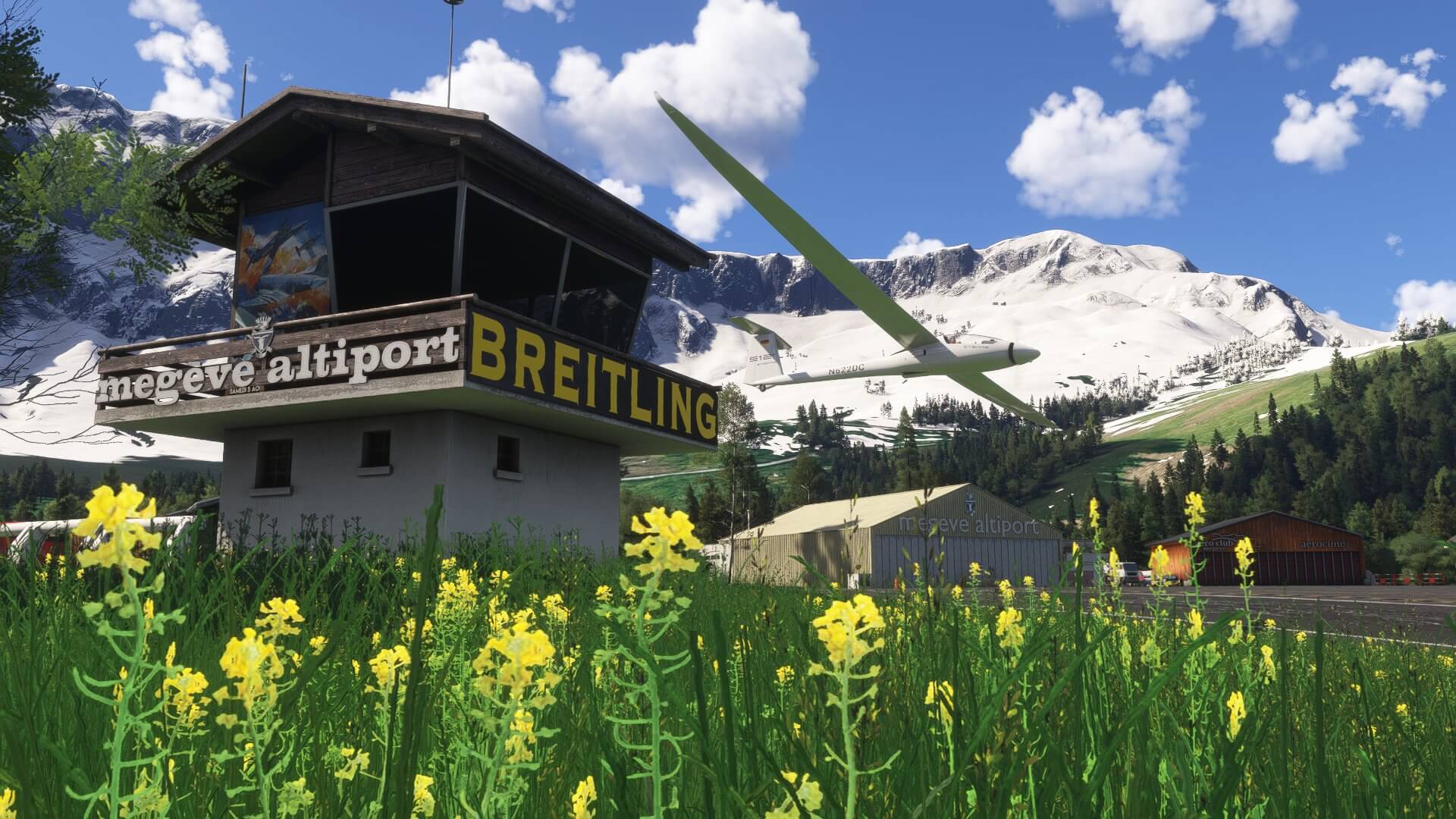 A glider passes low past a tower at Megeve altiport