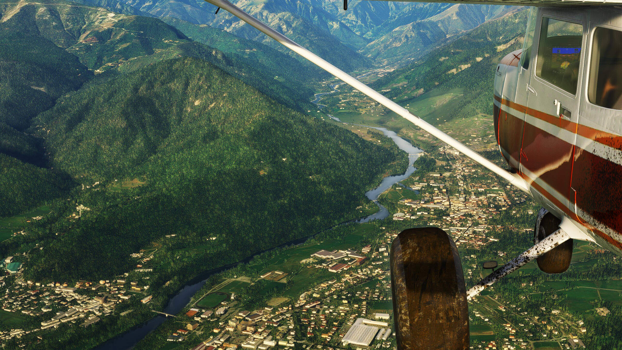 The view from a high wing Cessna aircraft flying through a valley