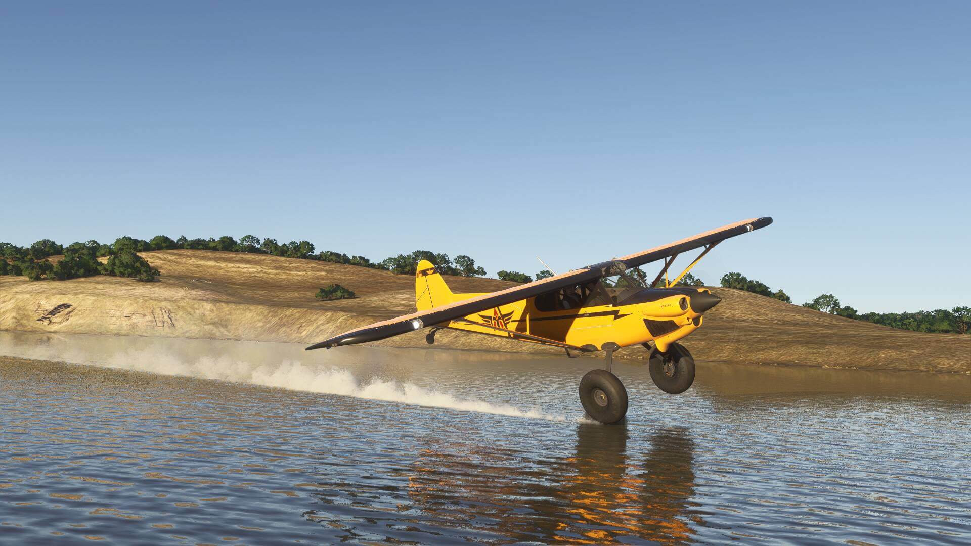A bush plane skims the surface of a river, kicking up a wake of water behind it.