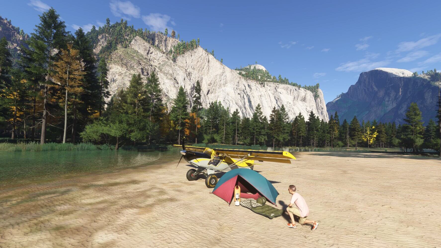 A camper sets up his tent next to his aircraft, parked in a mountainous valley