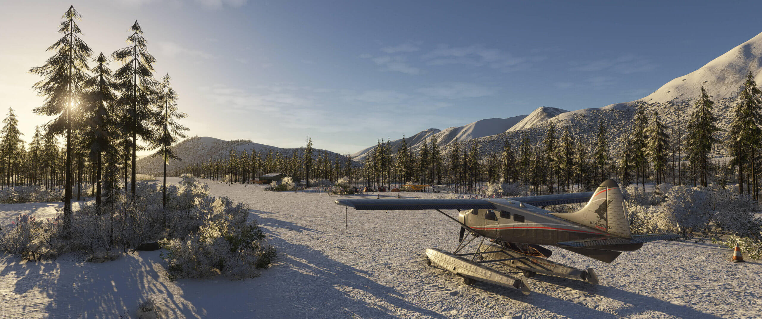 A high wing propeller aircraft with snow skis sits idle on a snowy runway strip in a valley
