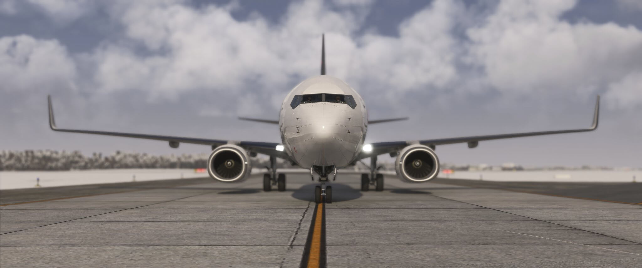 A Boeing 737 taxis at an airport with landing lights shining brightly