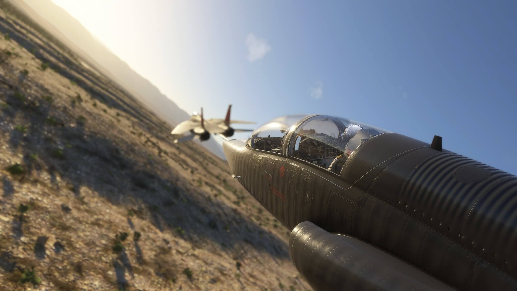Two fighter jets bank to the left whilst flying in close formation low to the ground