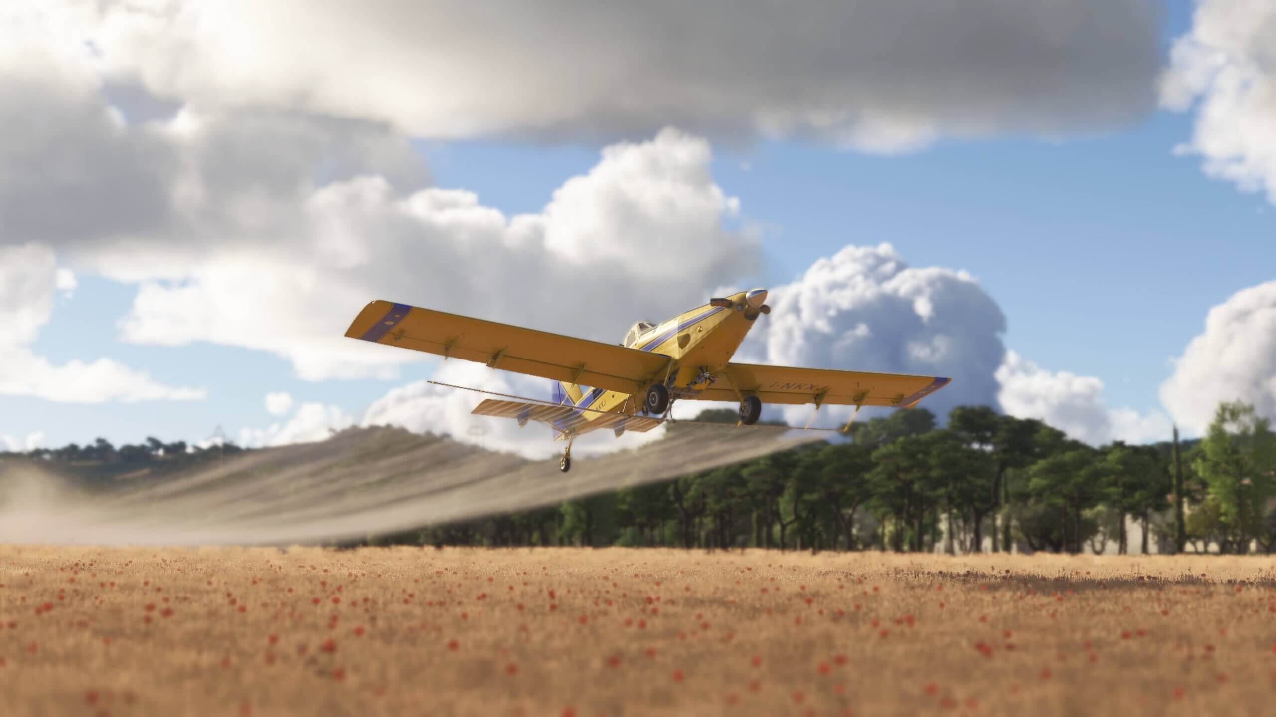 An agricultural aircraft sprays crops at low altitude