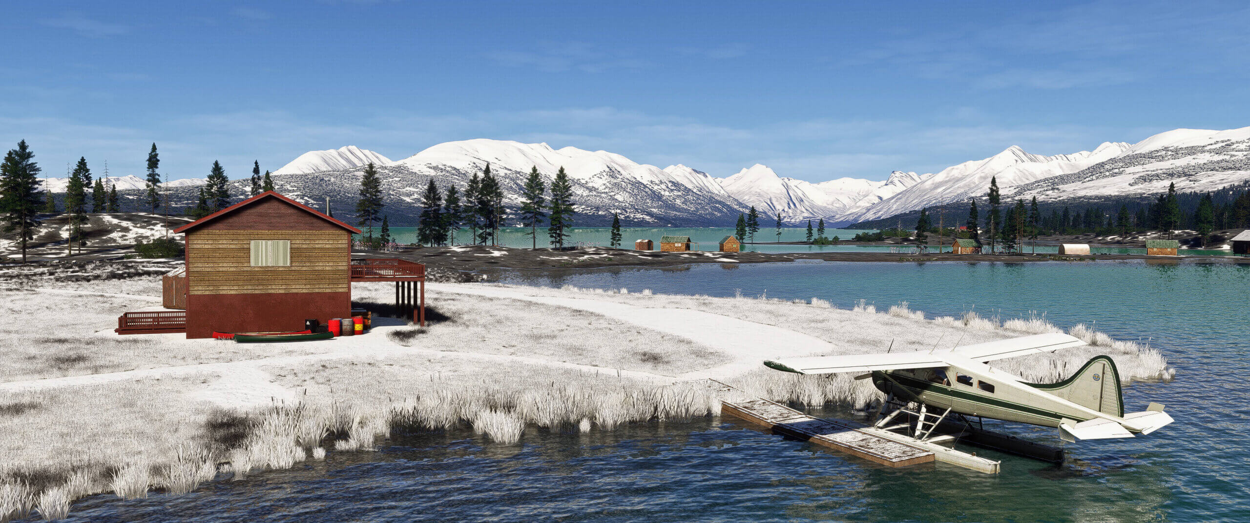 A high wing Cessna parked on a lake near a winter cabin