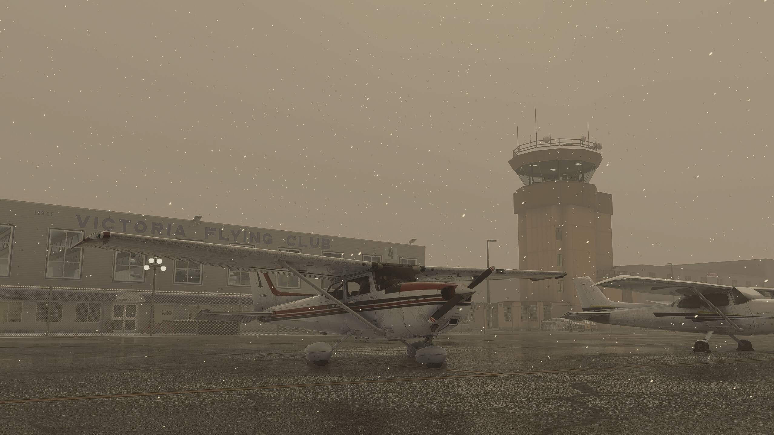 Cessna's sit on the ramp of an airport during a snow storm