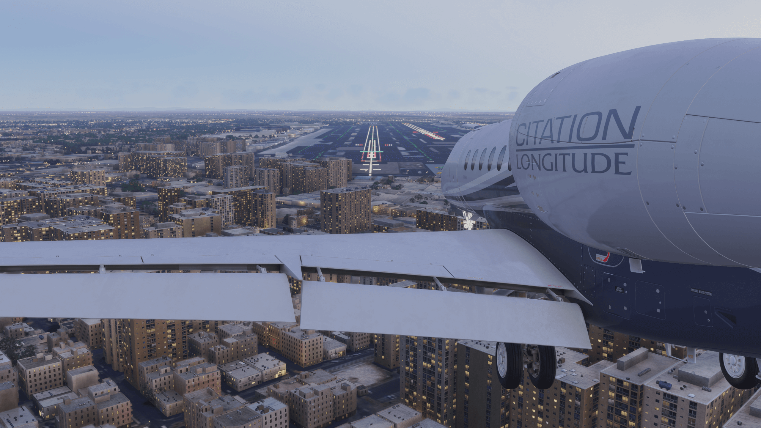 A Cessna Citation Longitude on final approach to land at an airport with runway lighting turned on
