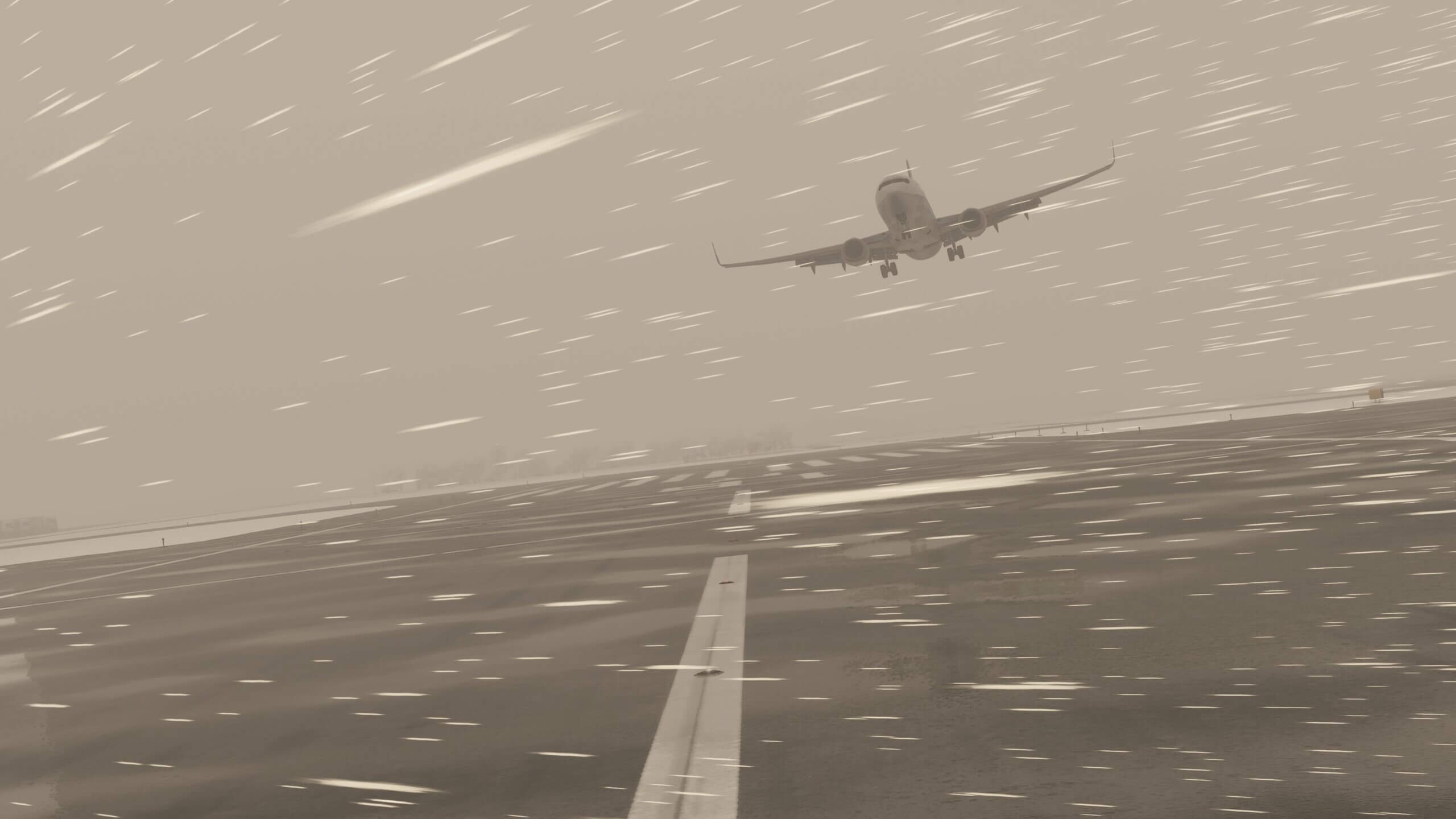 A Boeing 737 comes into land on an airport runway with strong crosswinds and snow