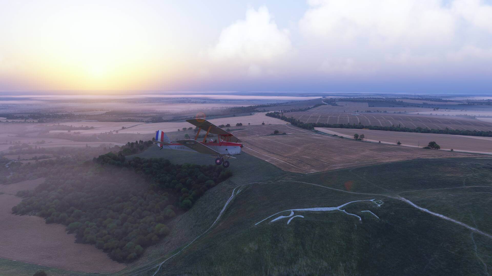 A dual wing propeller aircraft flies over the White Horse in Uffington, Oxfordshire