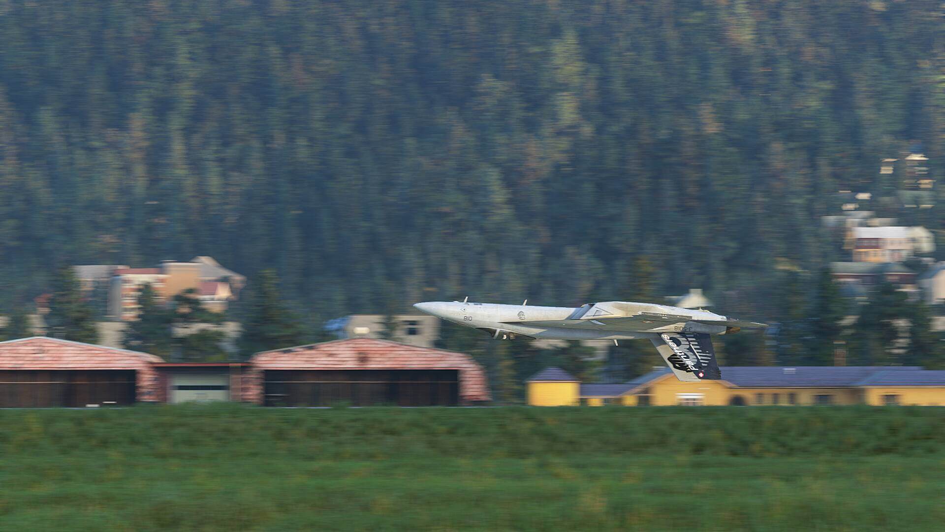 An F/A-18 Hornet flies inverted close to the ground