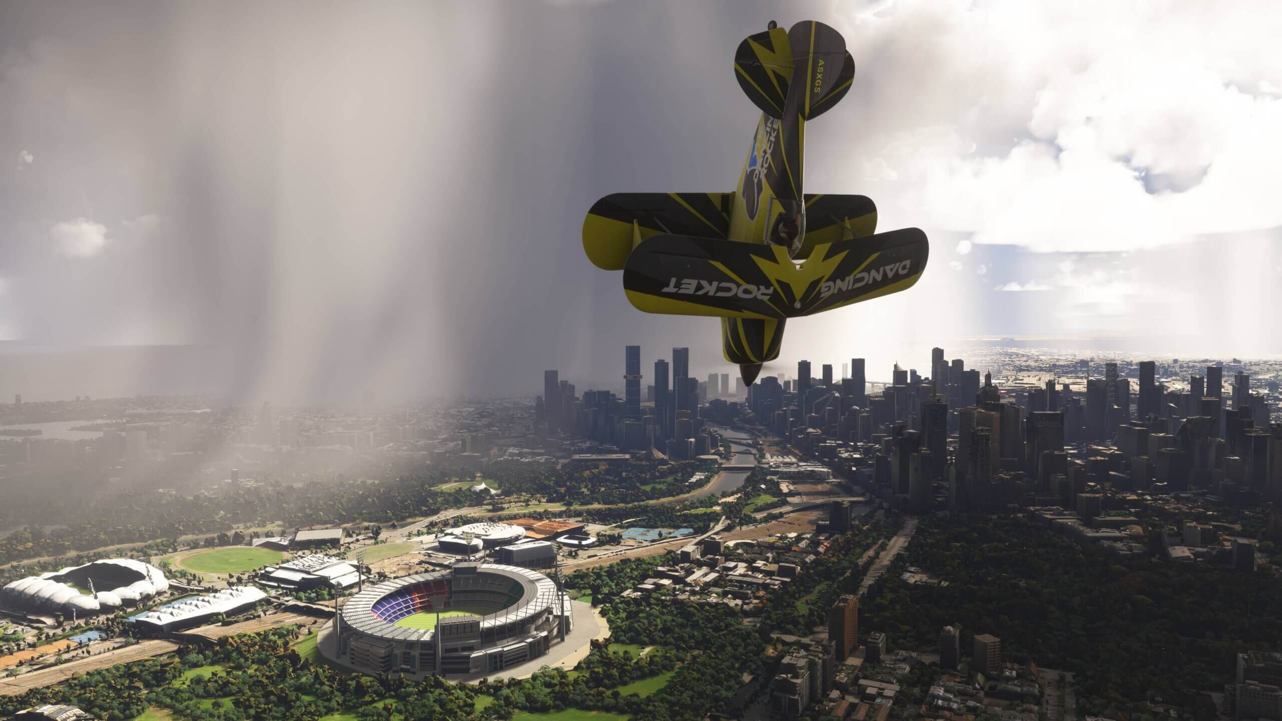 A dual wing yellow and black propeller aircraft performs a loop near Melbourne City, Australia