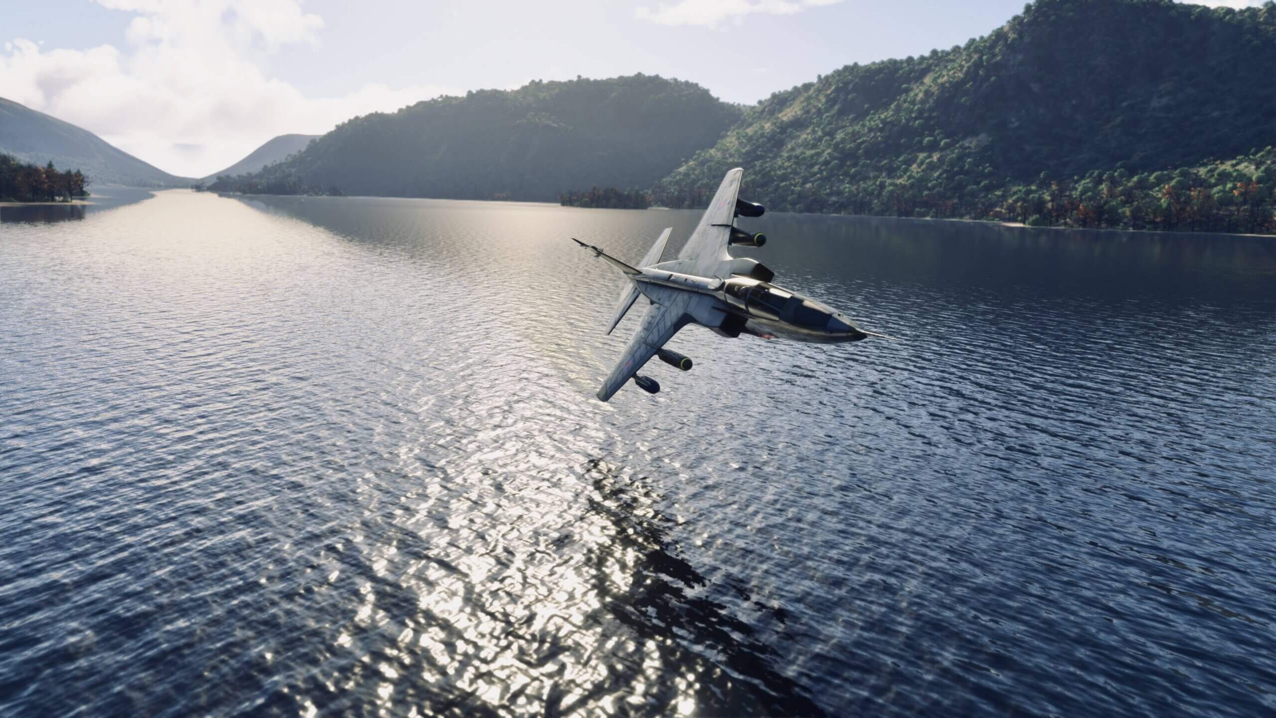 A fighter jet banks to the right whilst flying low over water in a valley