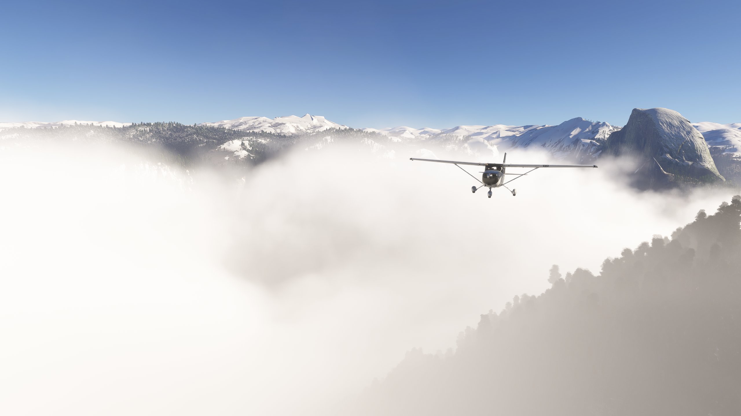 A Cessna 172 flies above thick cloud in a valley