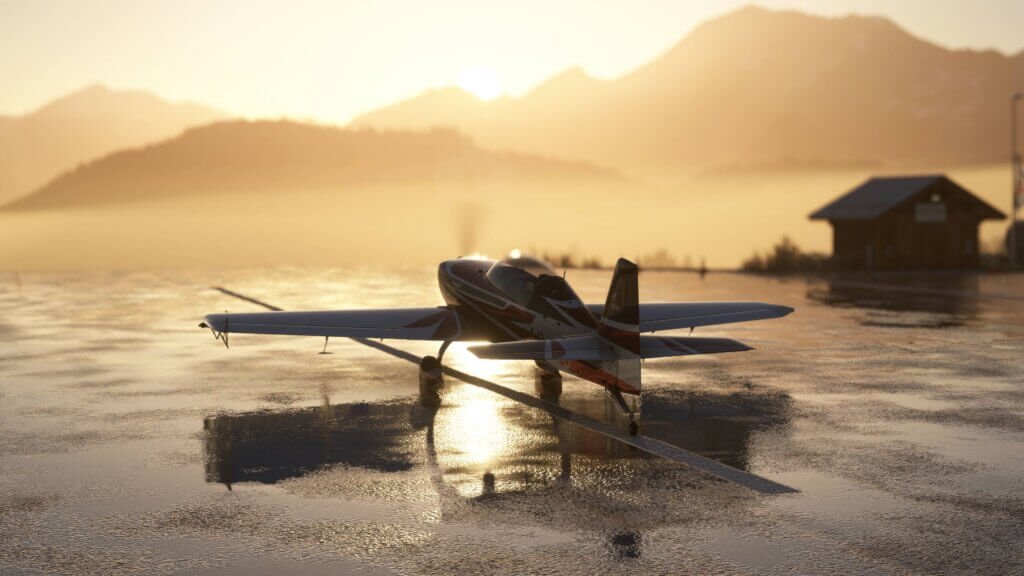 An Extra 330 parked on a wet runway ramp