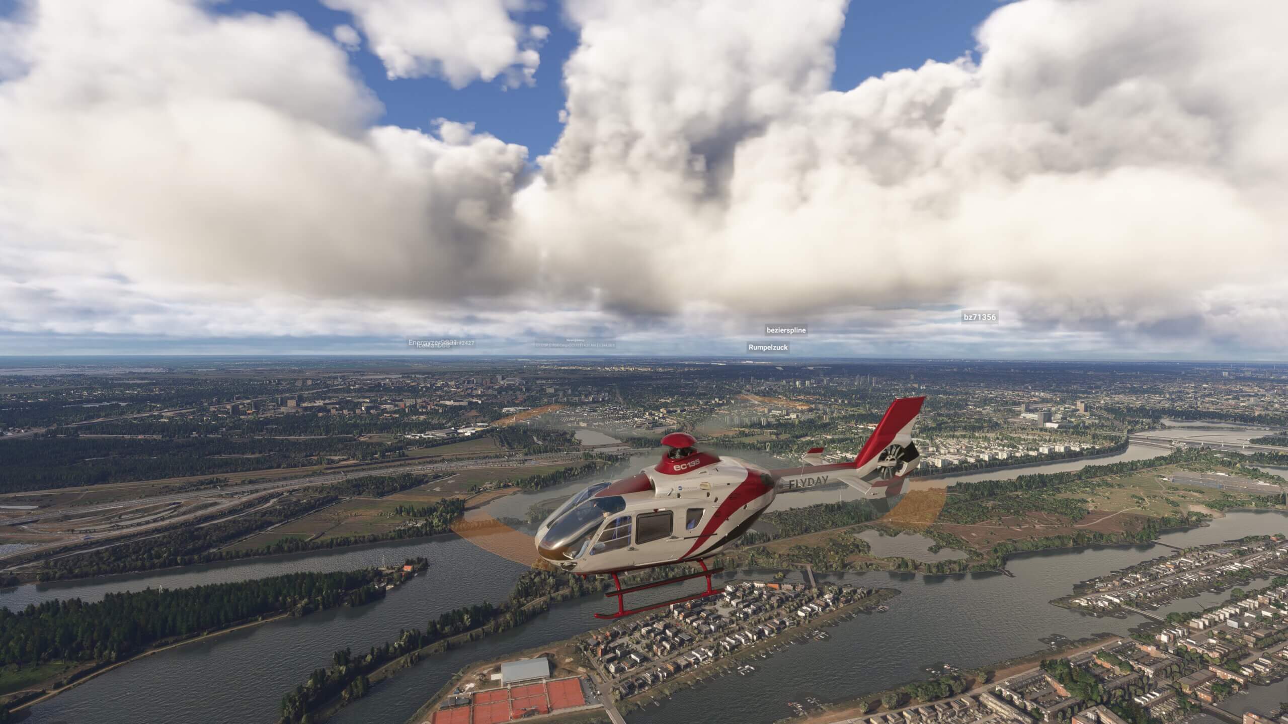 An EC135 helicopter flies low over a city