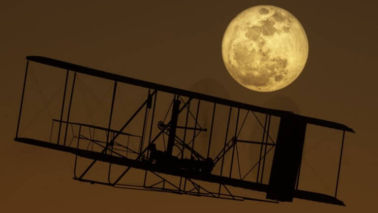 The Wright Brothers flyer silhouetted by the moon behind