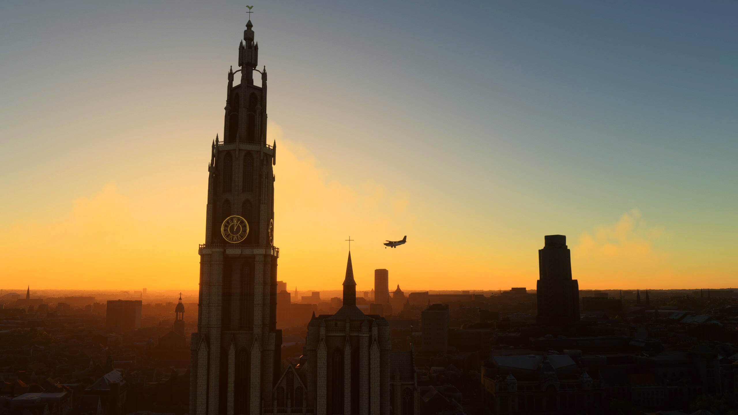 A high wing propeller aircraft flies near a church just after sunset