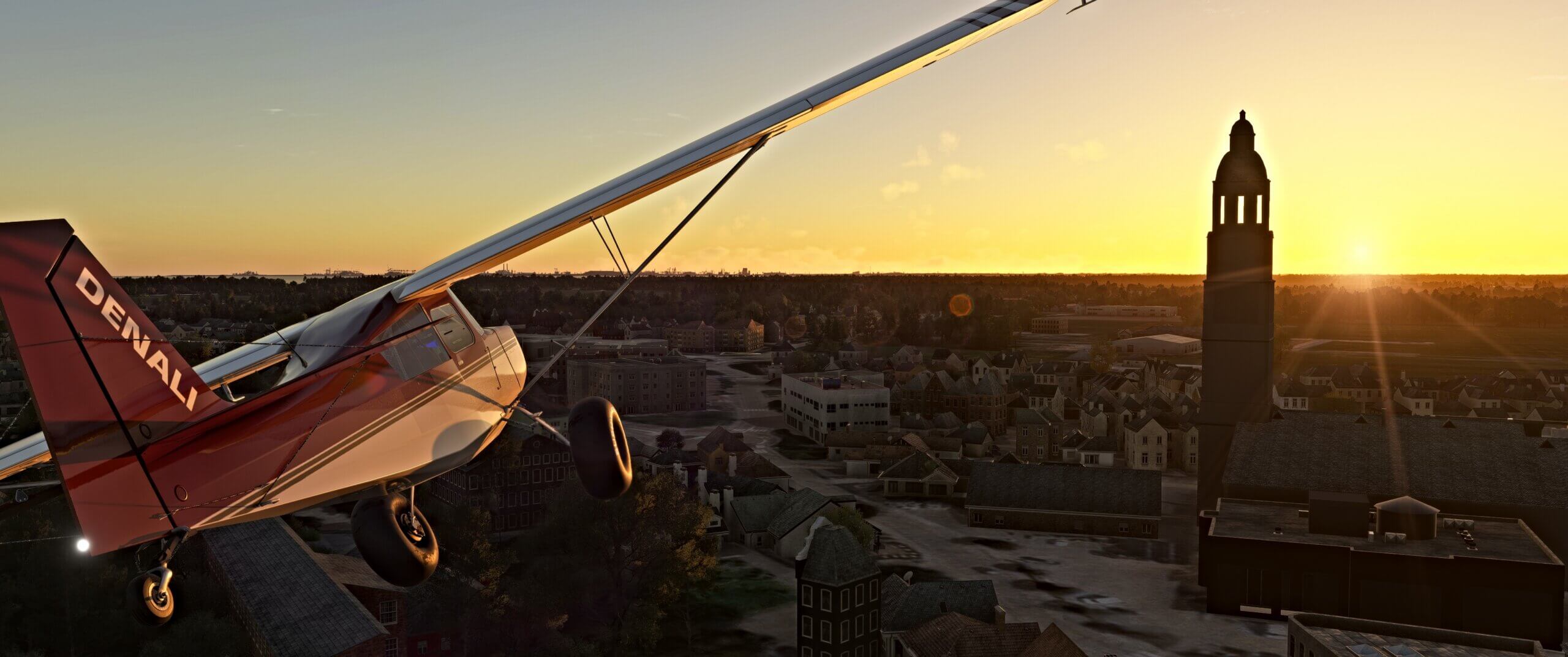 A high wing propeller aircraft flies near a church during sunset