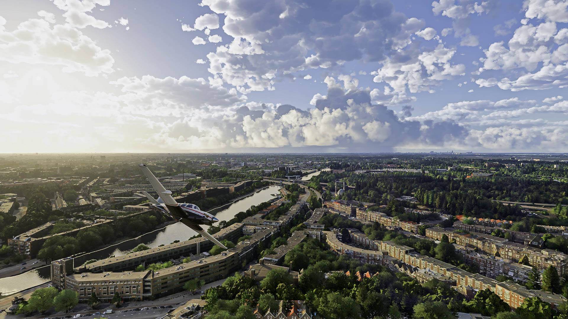 A low wing propeller aircraft flies over a city