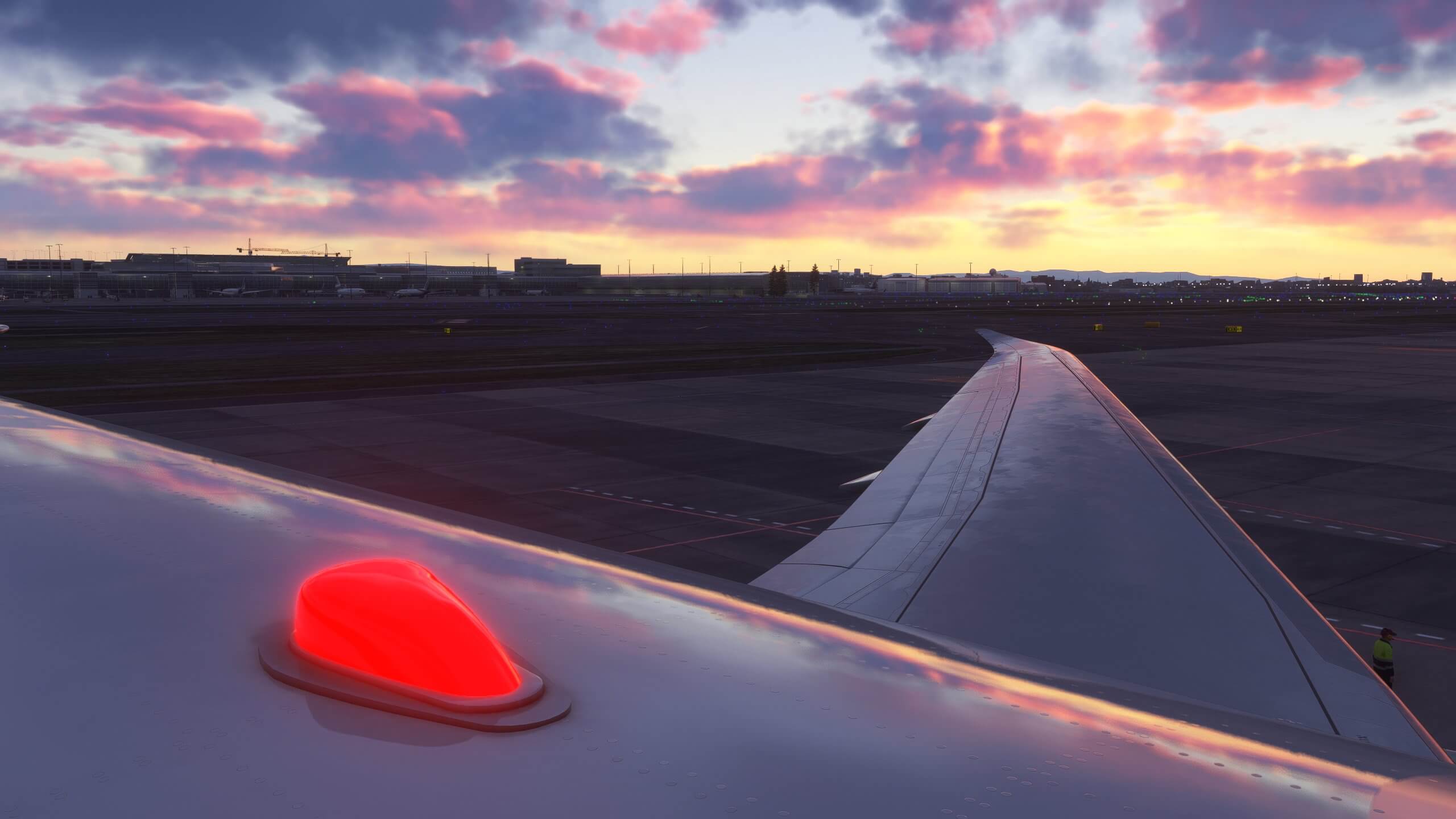 The beacon light flashing on top of an airliner parked on a ramp at sunset