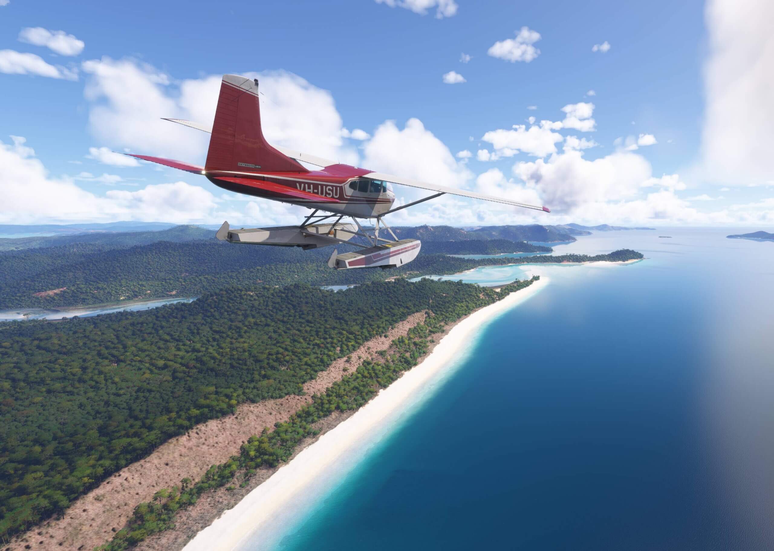 A high wing Cessna 185 Skywagon flies parallel along a beach