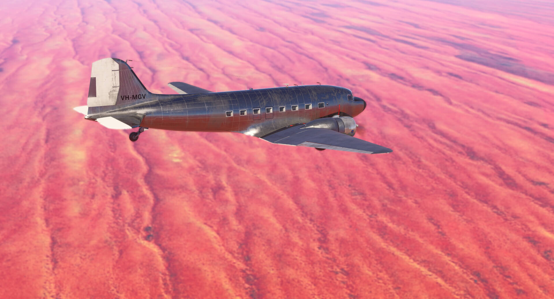 A DC-3 flies over a desert