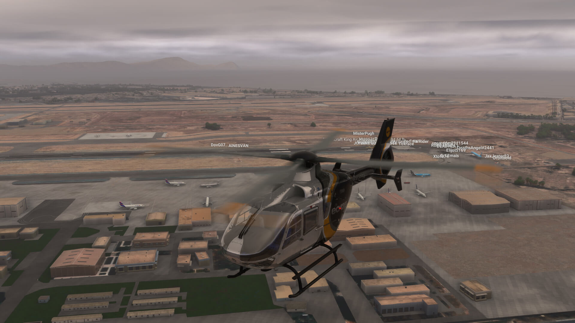 An EC135 helicopter flies over a busy airport
