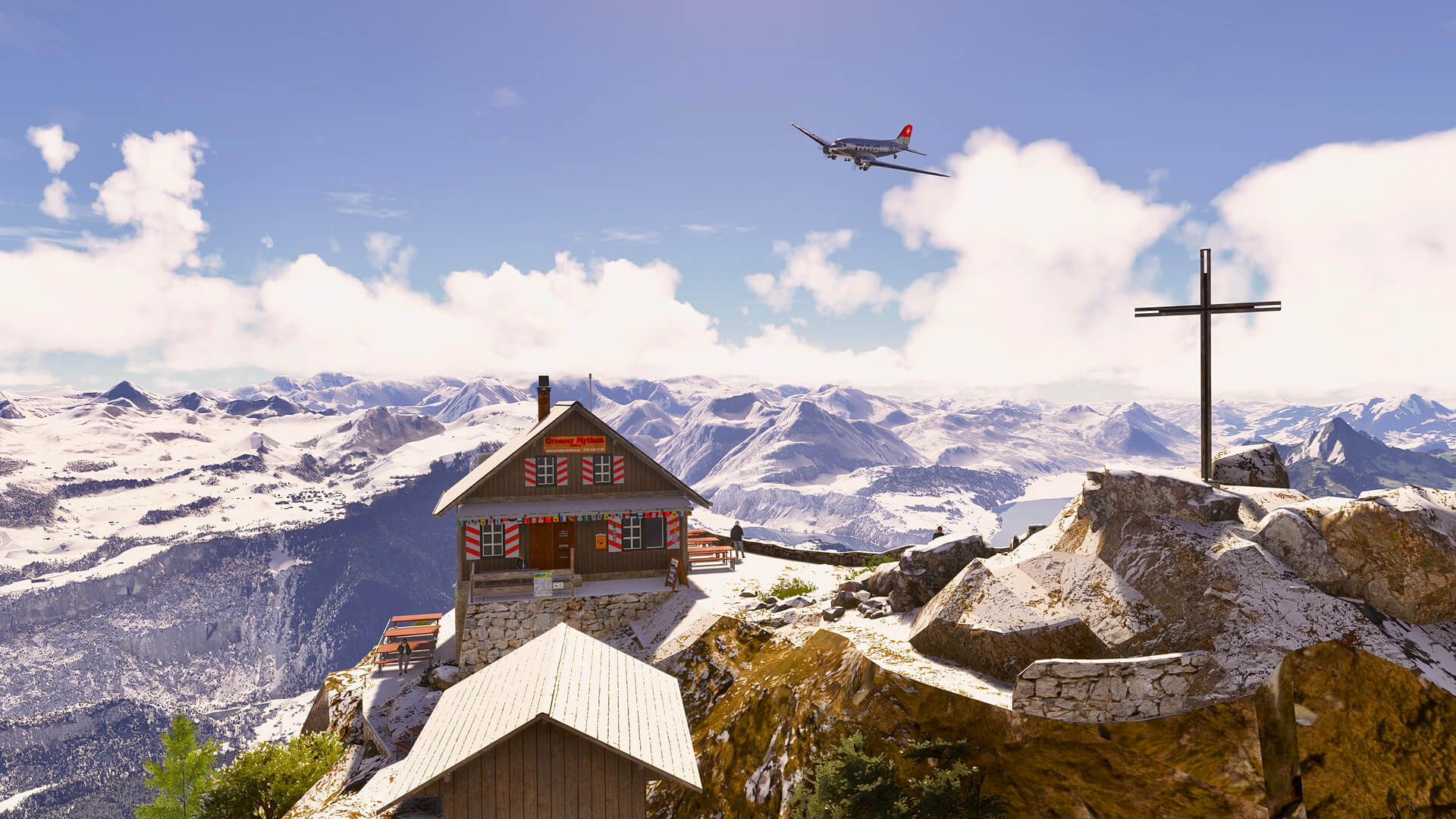 A DC-3 flies over a wooden hut in Switzerland