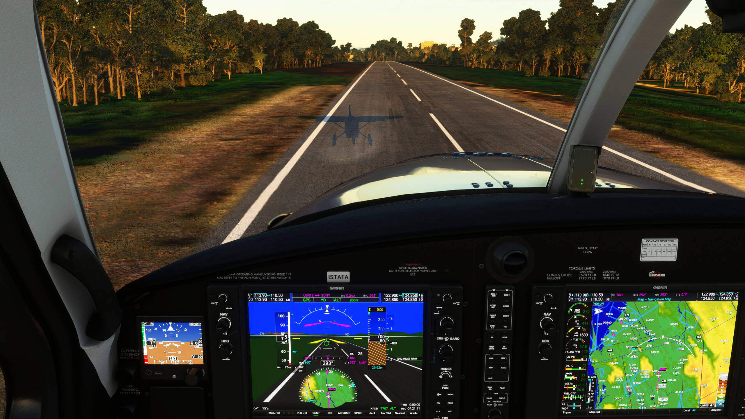 A cockpit view of a high-wing propeller aircraft coming in for landing over a runway
