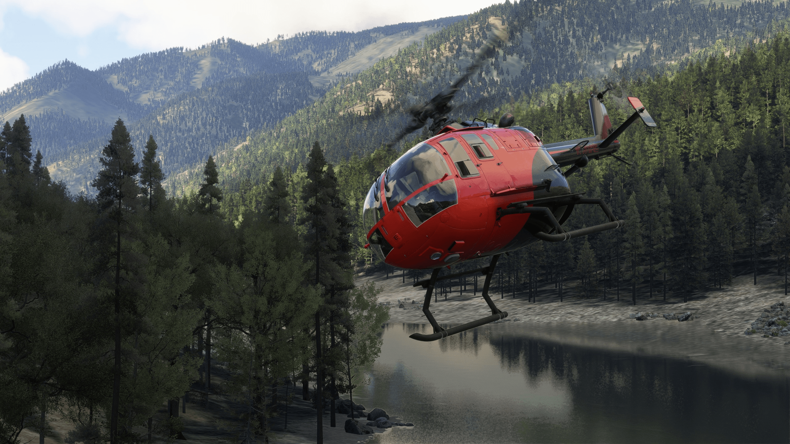 A red and black helicopter flies through a river valley