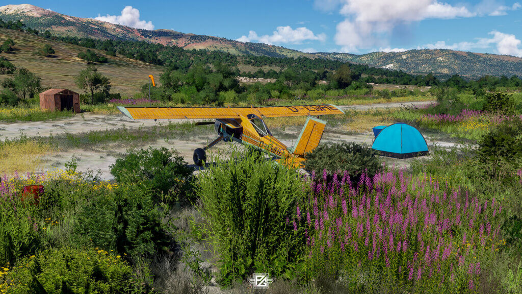 A yellow high-wing propeller aircraft sits idle with a blue tent next to it in a field