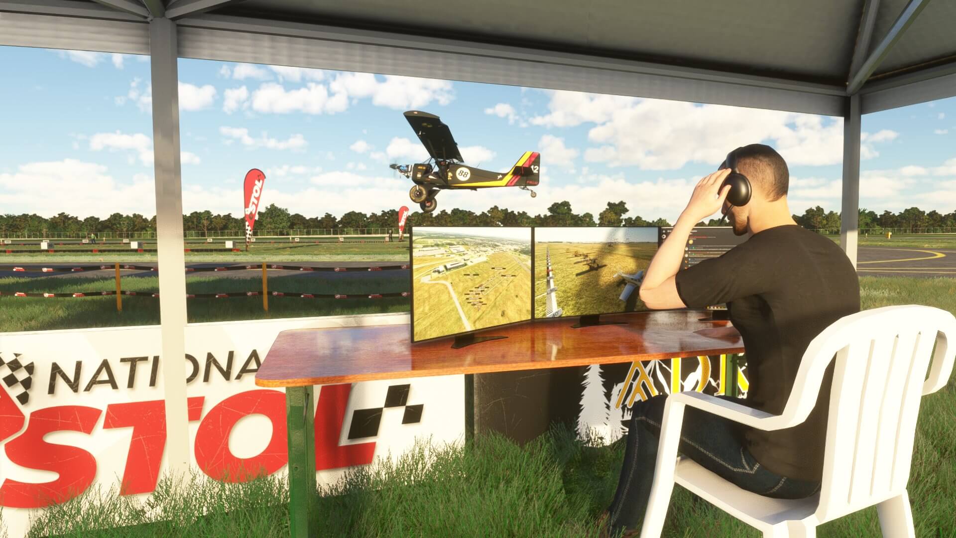 A commentator sits behind a table during a STOL drag race event