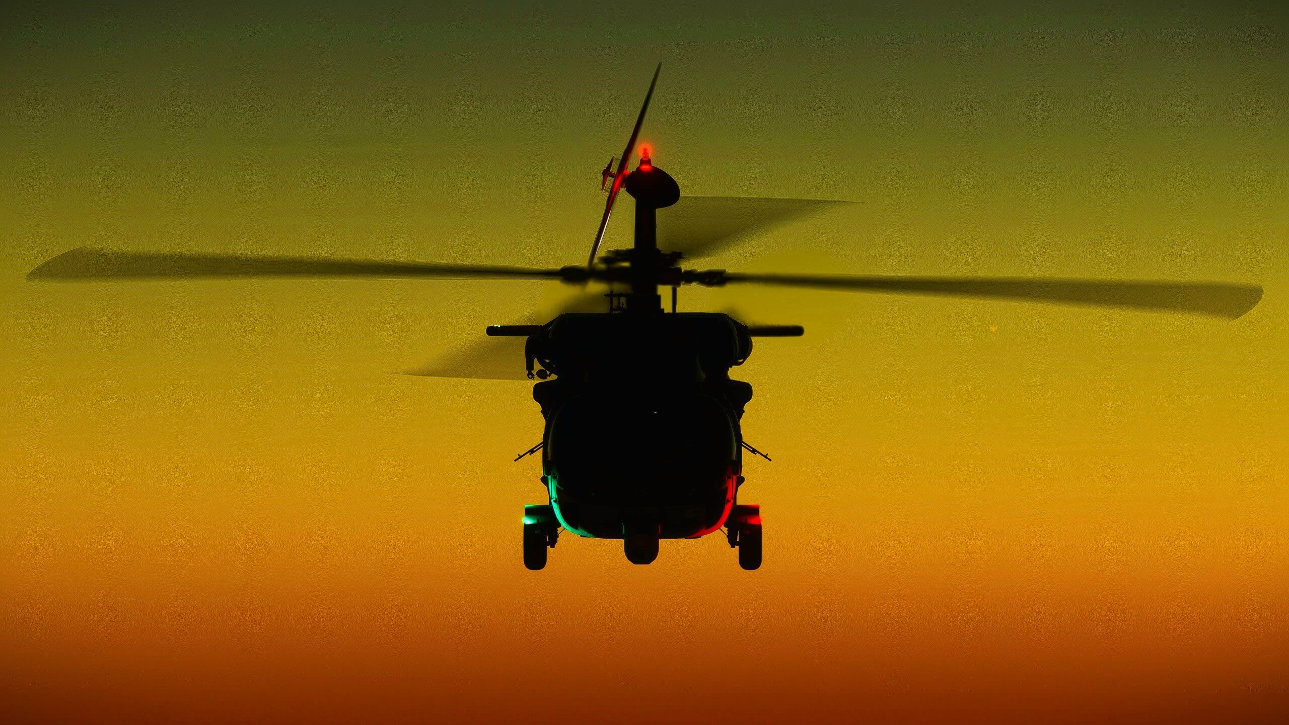 The silhouette of a Black Hawk helicopter at night