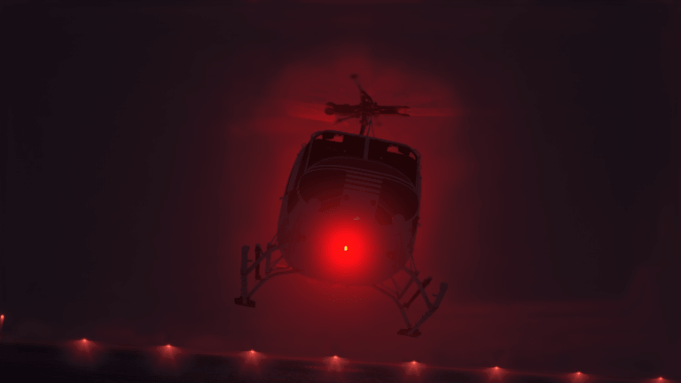 A helicopter with red beacon light flashing comes into land
