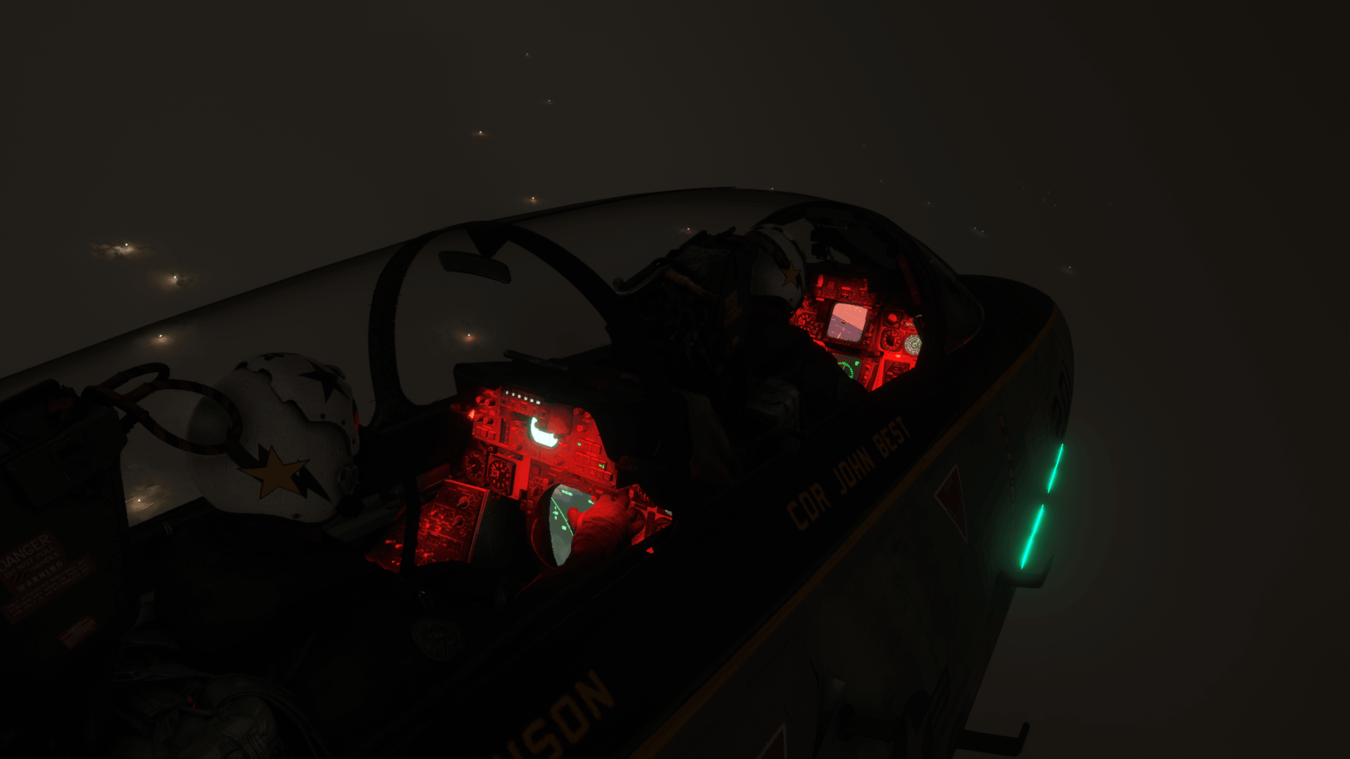 The cockpit of a fighter jet with red lighting illuminating the dashboards