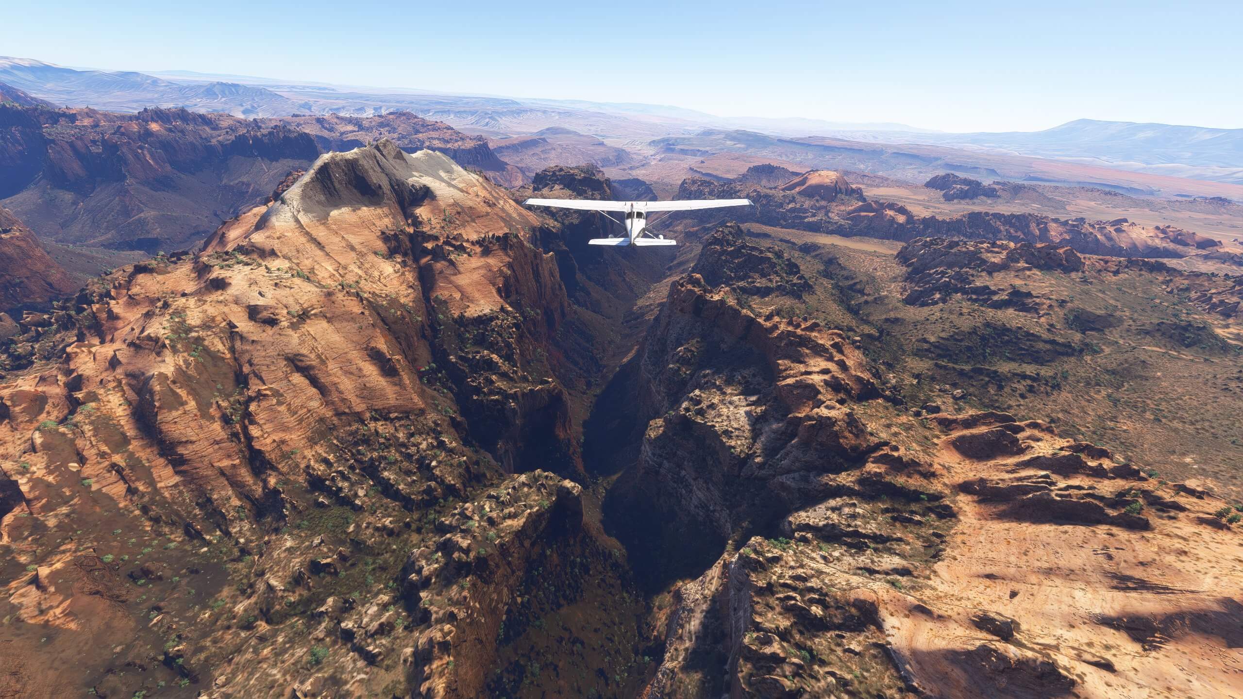 A high wing propeller aircraft flies above the valley of a US National Park