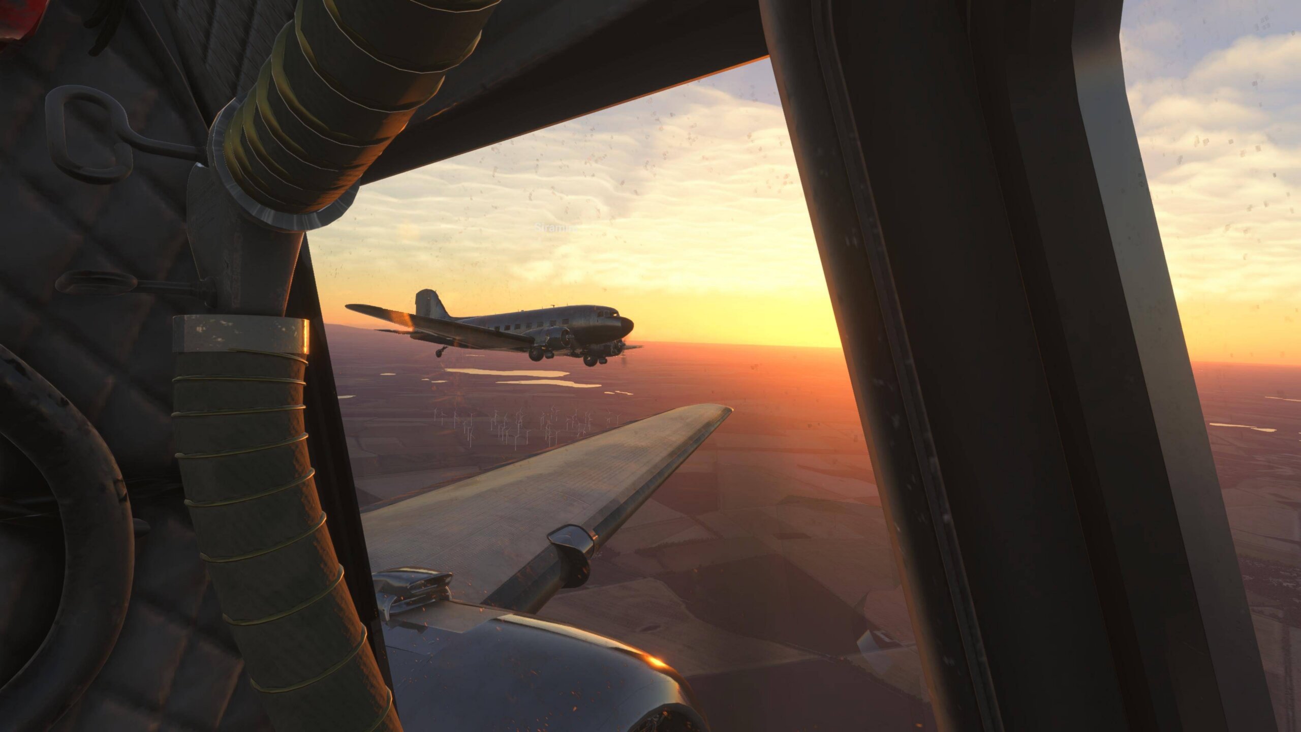 The wing view of a DC-3 flying in close formation with another aircraft of the same type