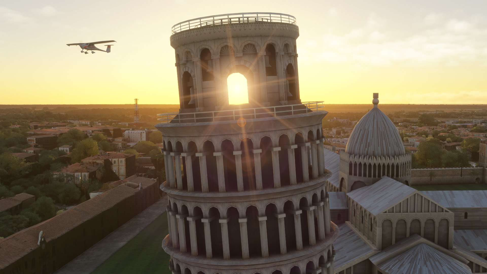 A high wing propeller aircraft flies past the Leaning Tower of Pisa