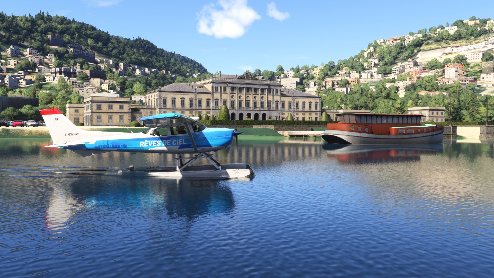 A blue high wing propeller aircraft resting on the water