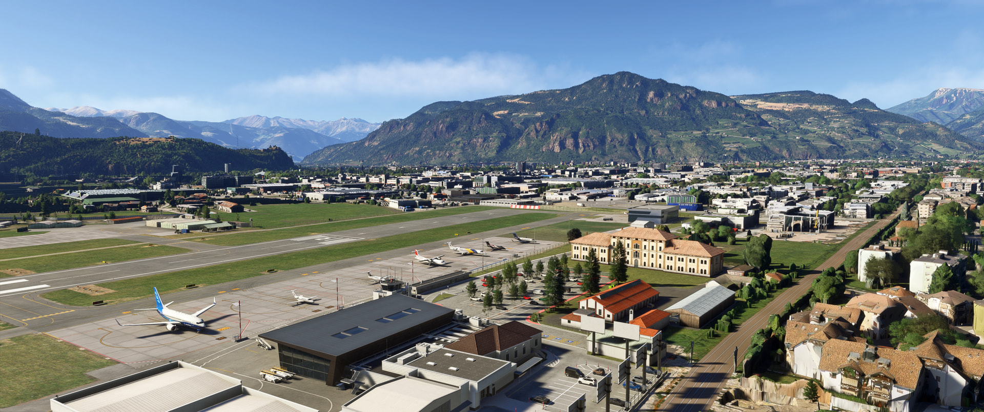 An airport with aircraft lined up on the apron in a valley