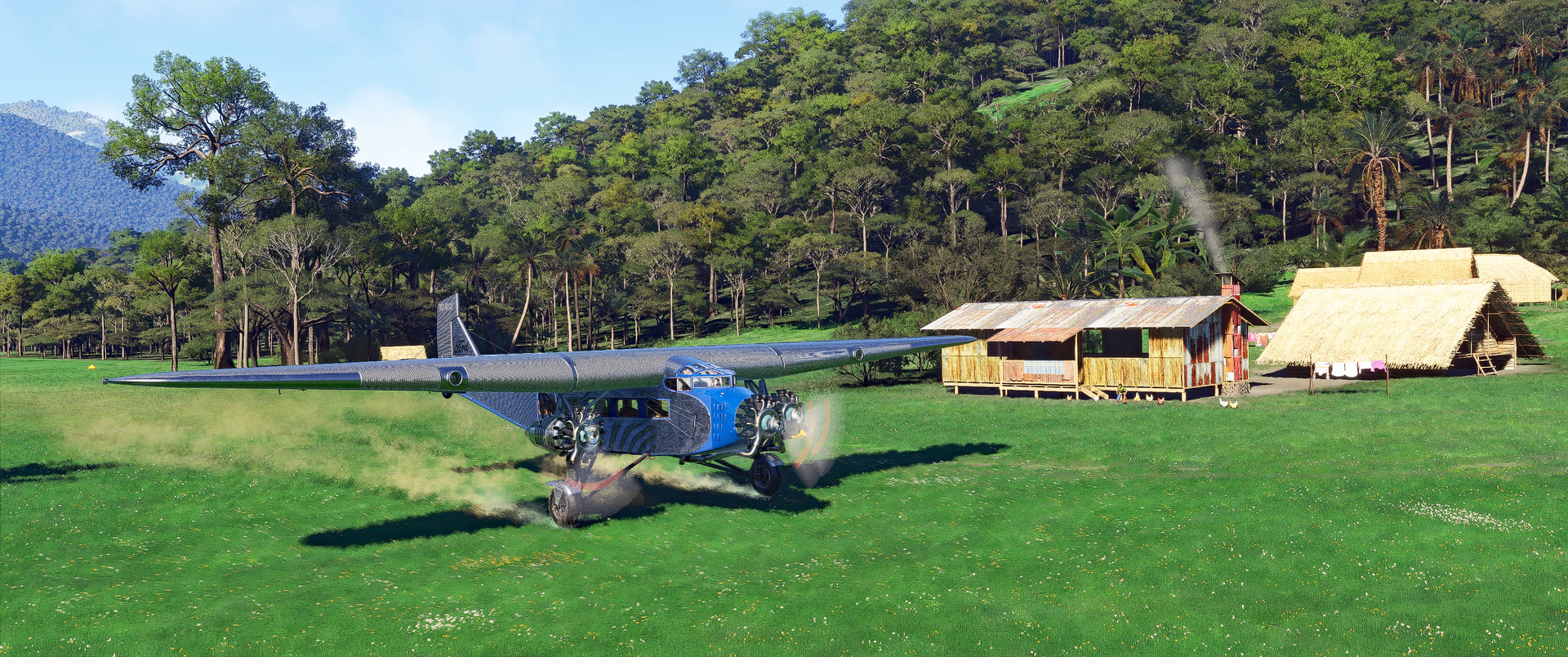 A high wing Tri-motor kicks up dirt during takeoff from a grass runway strip