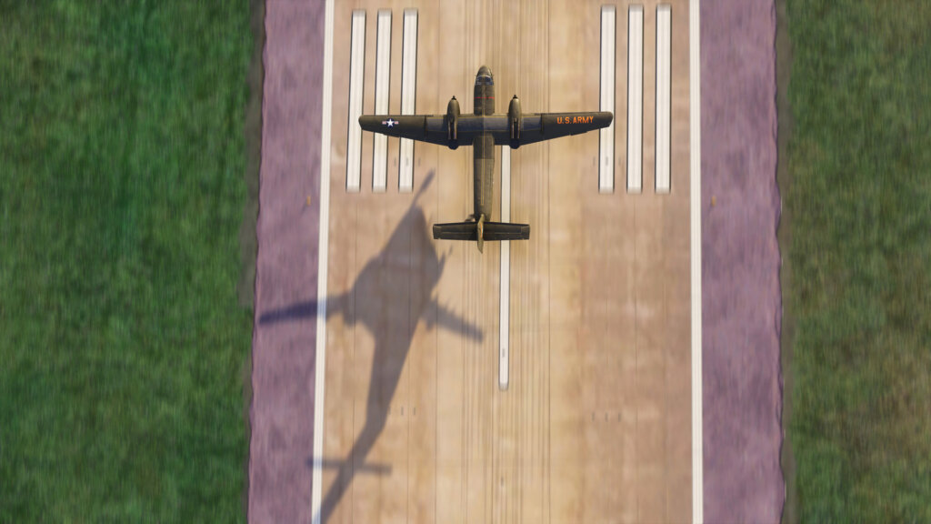 A high wing military aircraft departs from a runway from a birds-eye view
